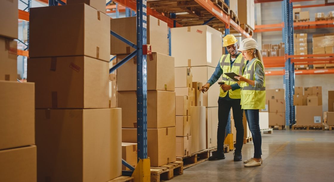 Dois trabalhadores de um centro logístico analisando o estoque